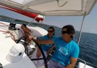 skipper and girl behind steering wheel of trimaran neel 45 yacht 2